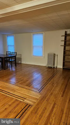 a view of empty room with furniture and wooden floor
