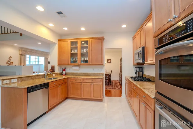 a large kitchen with stainless steel appliances granite countertop a stove and a sink