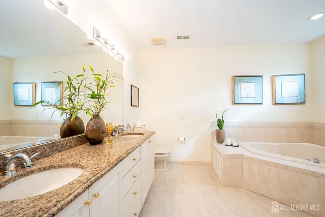 a bathroom with a granite countertop sink a toilet and bathtub