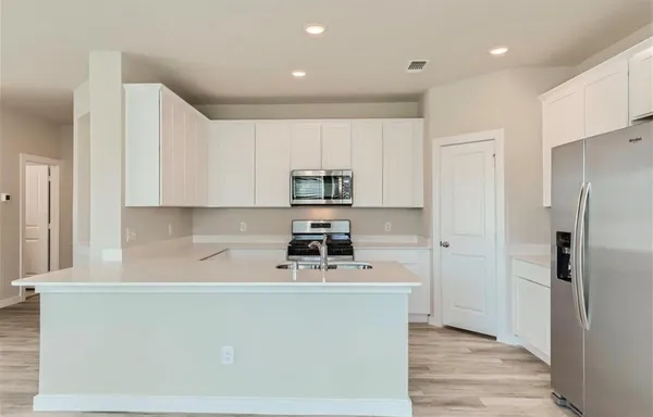 a kitchen with stainless steel appliances a refrigerator stove and microwave