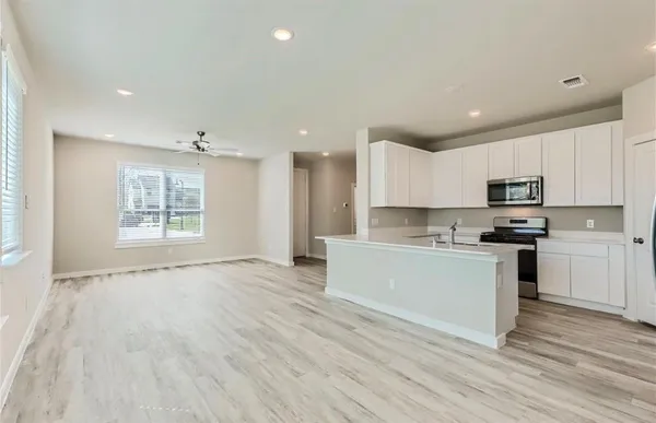 a kitchen with stainless steel appliances granite countertop a stove a sink and a microwave