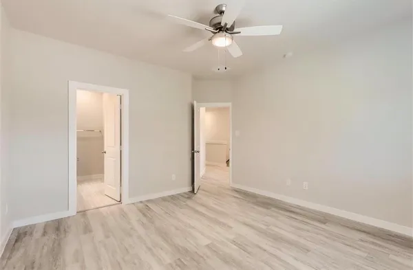 an empty room with a window and a ceiling fan