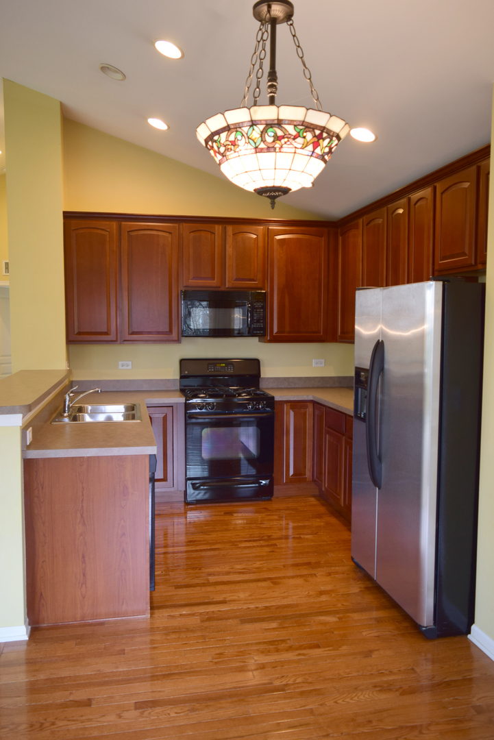 420 Valentine Way Oswego, IL 60543 - Photo 7 of 20 a kitchen with stainless steel appliances a stove a refrigerator and a microwave