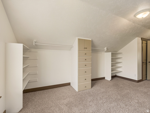 1279 West 1500th Street North Mapleton, UT 84664 - Photo 48 of 83 Carpeted closet space featuring built-in shelving, hanging rods, and a multi-drawer cabinet with upper doors