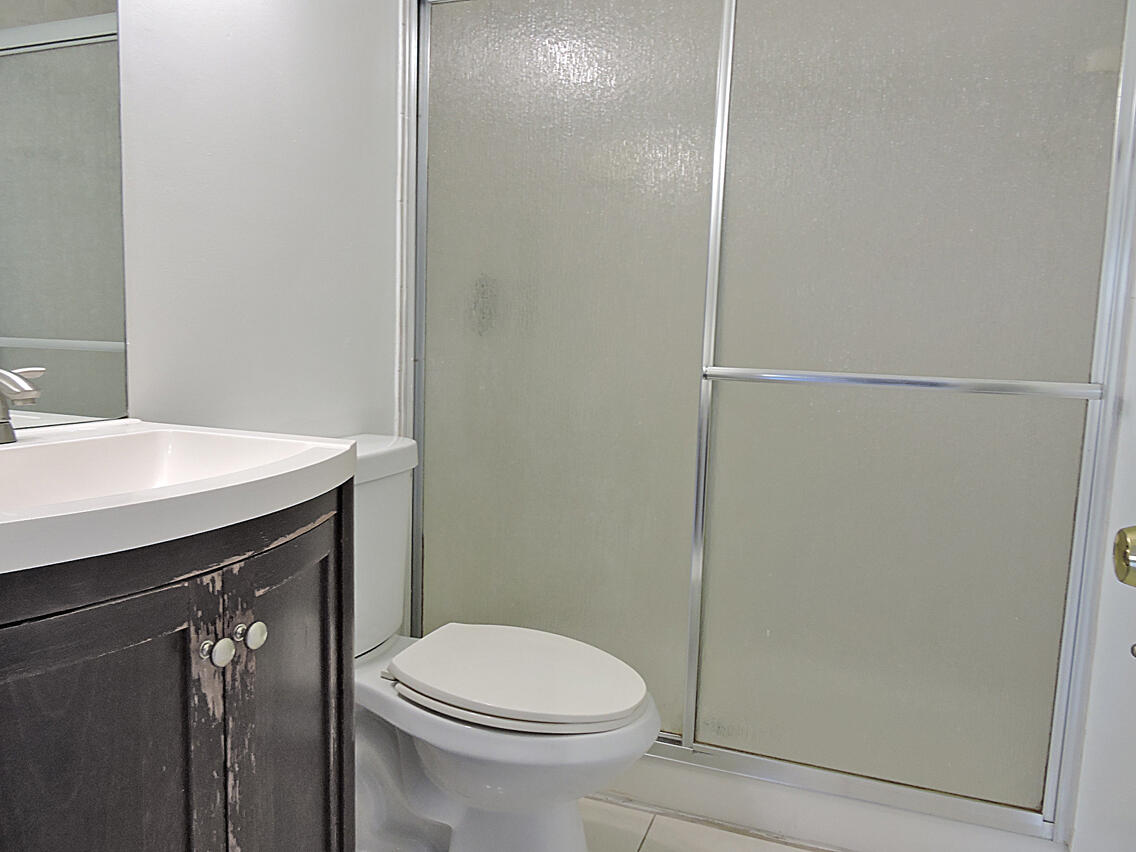 5040 Society Place East, Unit E West Palm Beach, FL 33415 - Photo 18 of 26 a bathroom with a sink a toilet and shower