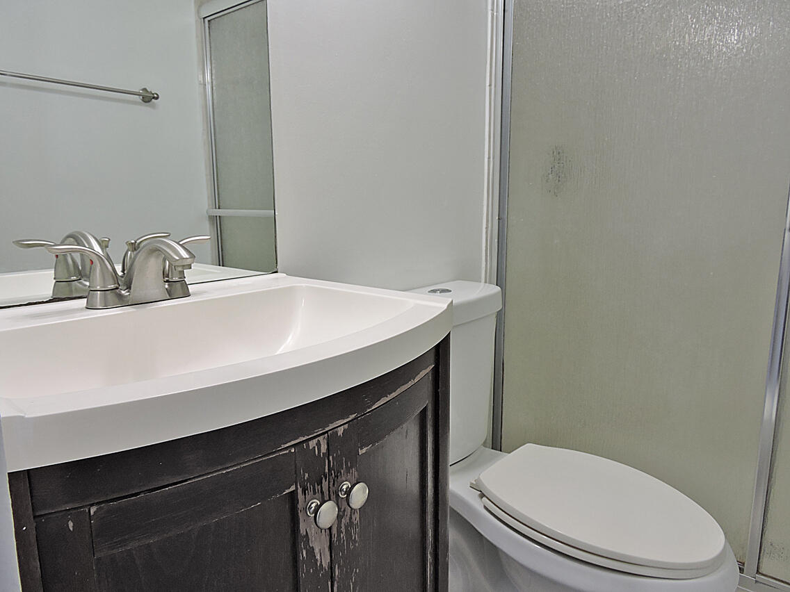 5040 Society Place East, Unit E West Palm Beach, FL 33415 - Photo 19 of 26 a bathroom with a sink a toilet and mirror