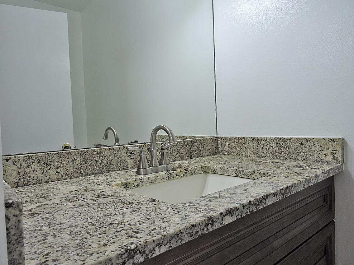 5040 Society Place East, Unit E West Palm Beach, FL 33415 - Photo 2 of 26 a bathroom with a granite countertop sink and a mirror