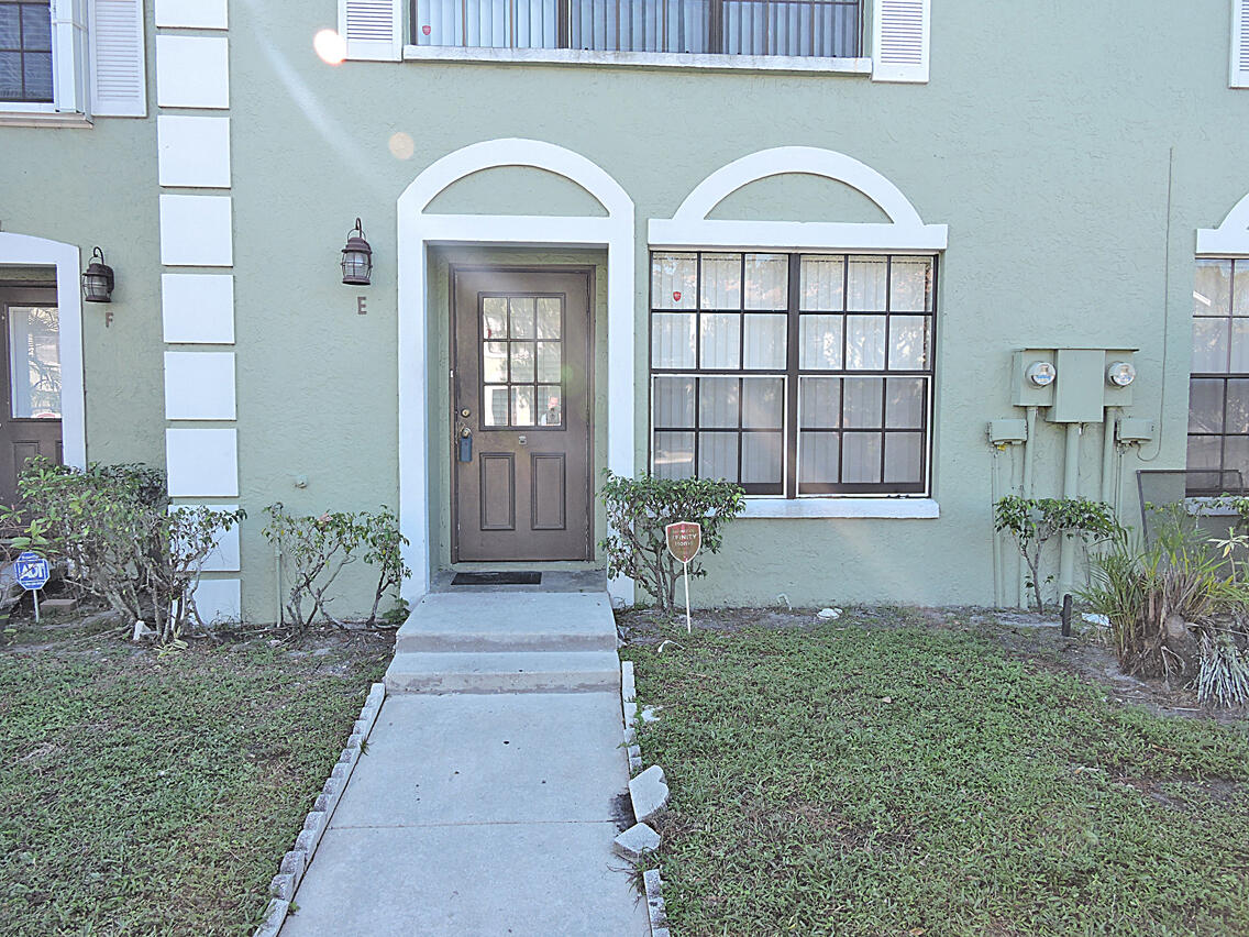 5040 Society Place East, Unit E West Palm Beach, FL 33415 - Photo 25 of 26 a front view of a house with garden