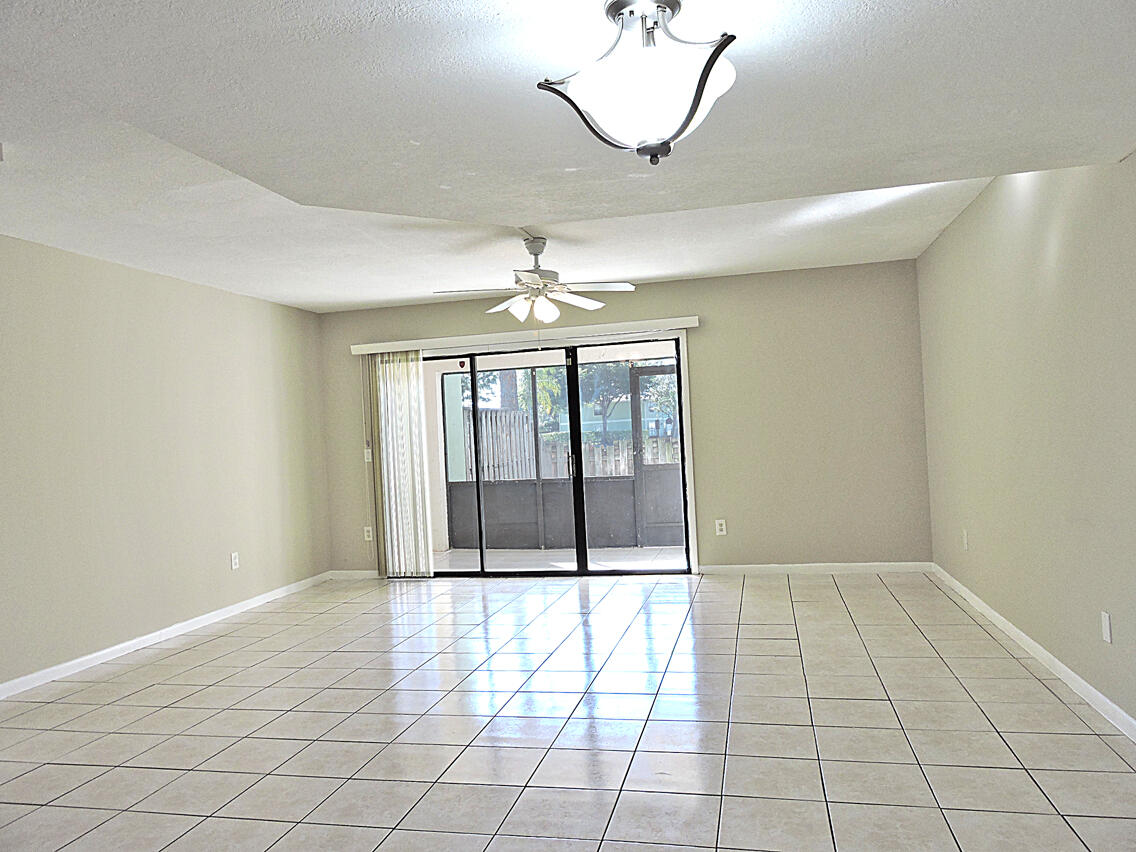 5040 Society Place East, Unit E West Palm Beach, FL 33415 - Photo 6 of 26 a view of a livingroom with a chandelier fan and windows