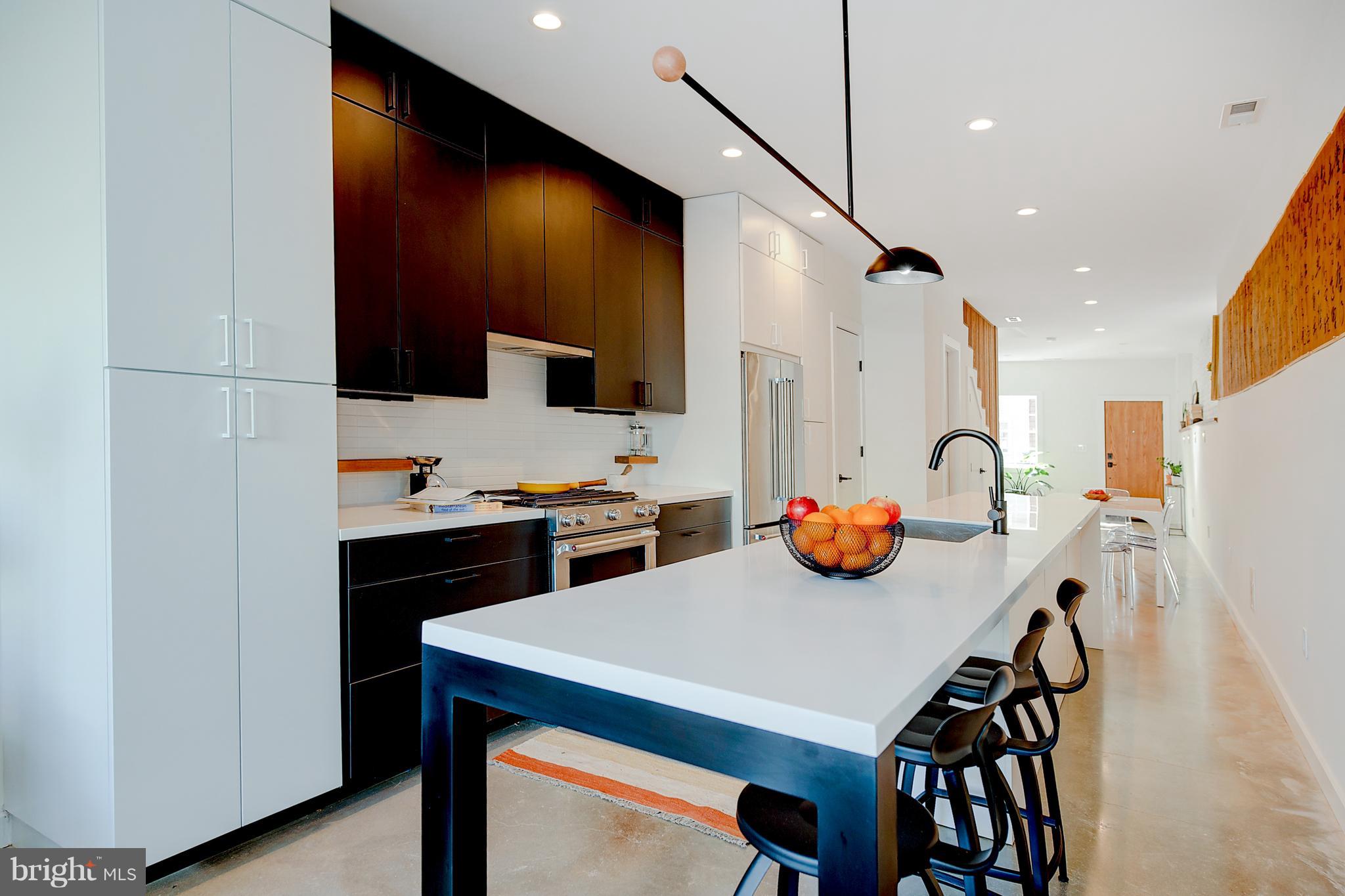 443 Ridge Street Northwest Washington, DC 20001 - Photo 13 of 47 a kitchen with stainless steel appliances a table chairs in it and wooden floors