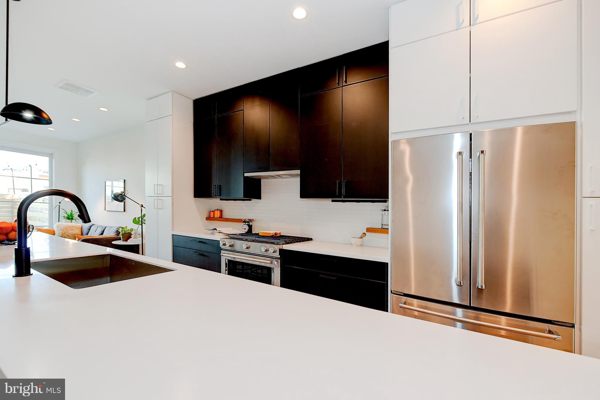 443 Ridge Street Northwest Washington, DC 20001 - Photo 15 of 47 a kitchen with stainless steel appliances a refrigerator sink and white cabinets
