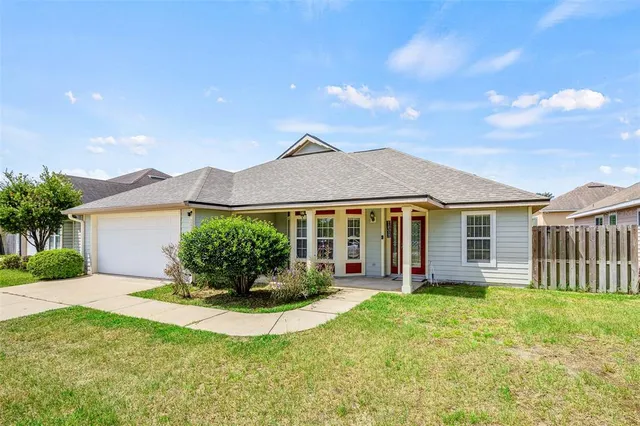 a view of a house with a yard and potted plants