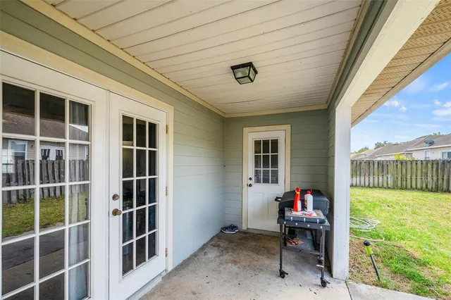 a view of a porch with furniture and floor to ceiling window