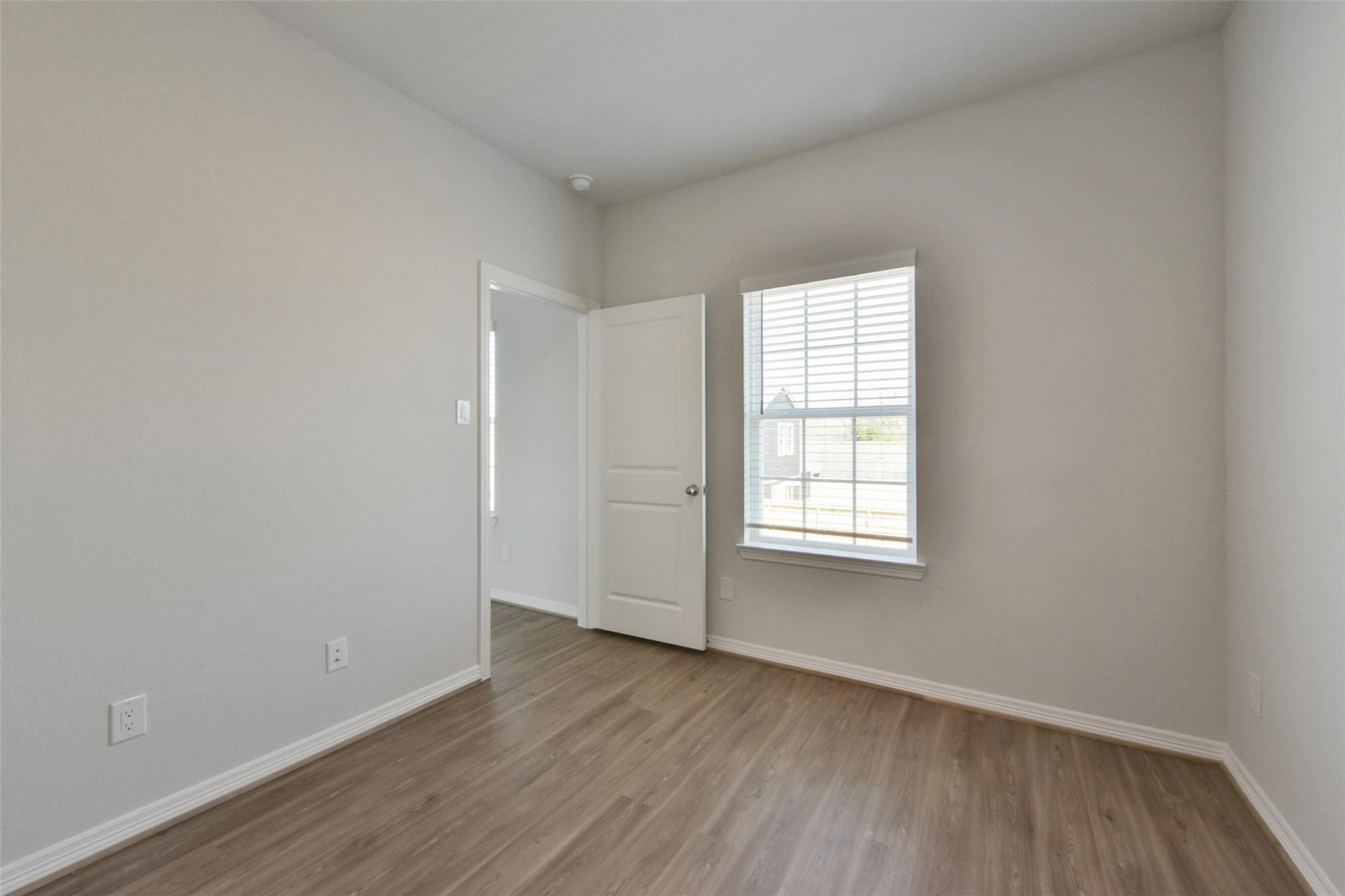 6835 New York Street Houston, TX 77021 - Photo 8 of 12 an empty room with wooden floor and windows