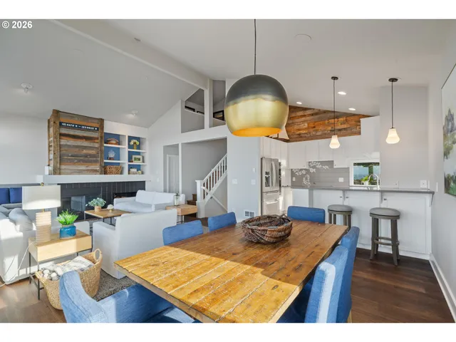 a kitchen with stainless steel appliances granite countertop a stove a sink a dining table and chairs with wooden floor