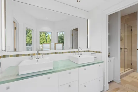 a bathroom with double vanity sinks and a bathtub