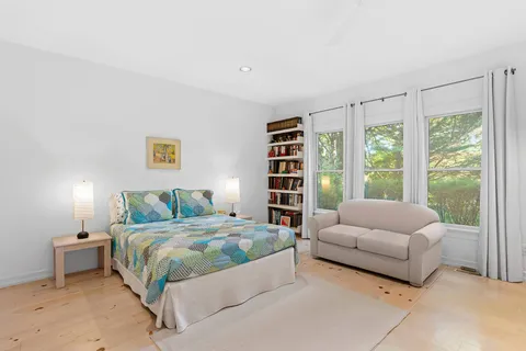 a bedroom with a bed couch and a large window