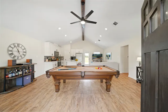 a living room with kitchen furniture and a wooden floor