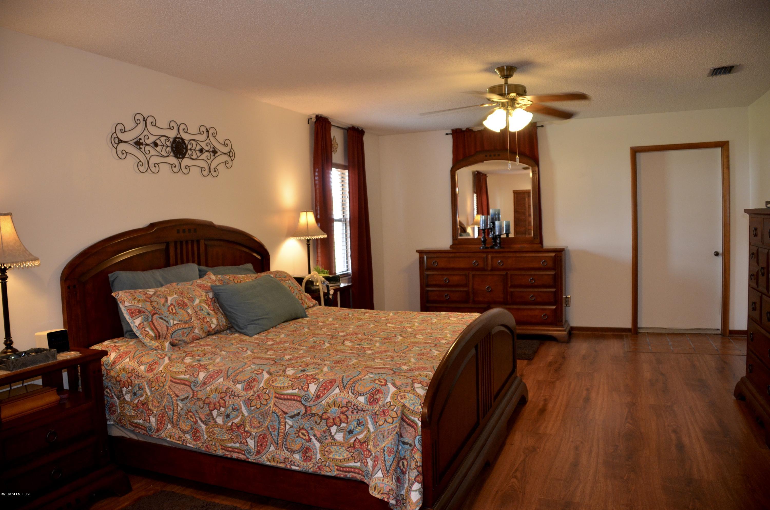 540516 Lem Turner Road Callahan, FL 32011 - Photo 15 of 26 a bedroom with a bed and a chandelier