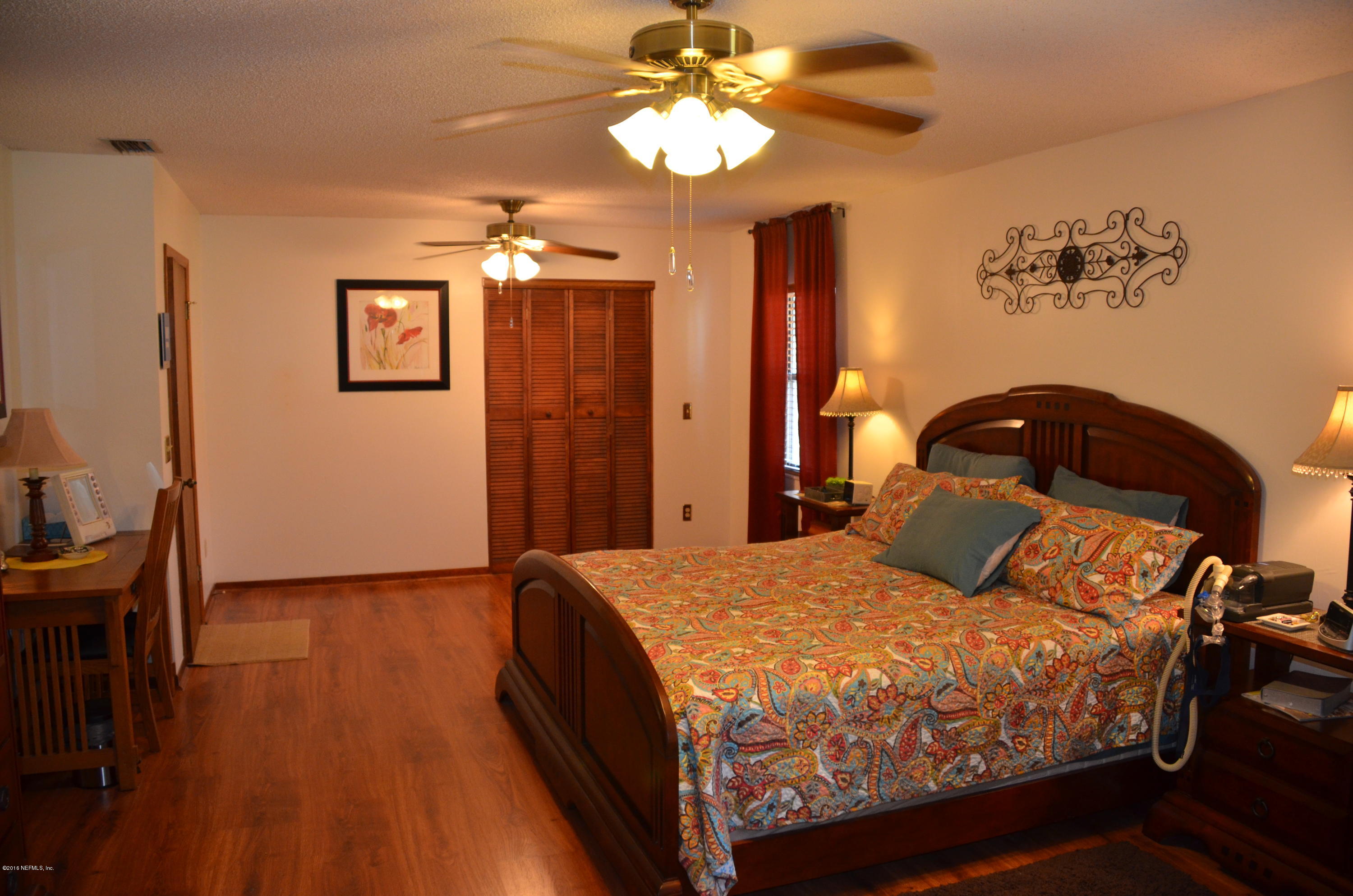540516 Lem Turner Road Callahan, FL 32011 - Photo 16 of 26 a bedroom with a bed and a chandelier