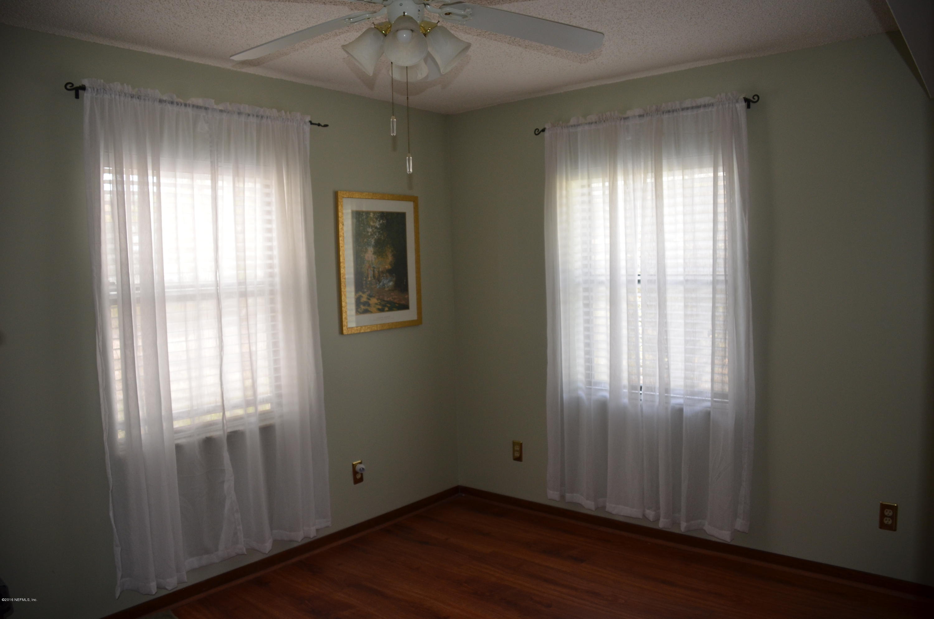 540516 Lem Turner Road Callahan, FL 32011 - Photo 21 of 26 an empty room with wooden floor and windows