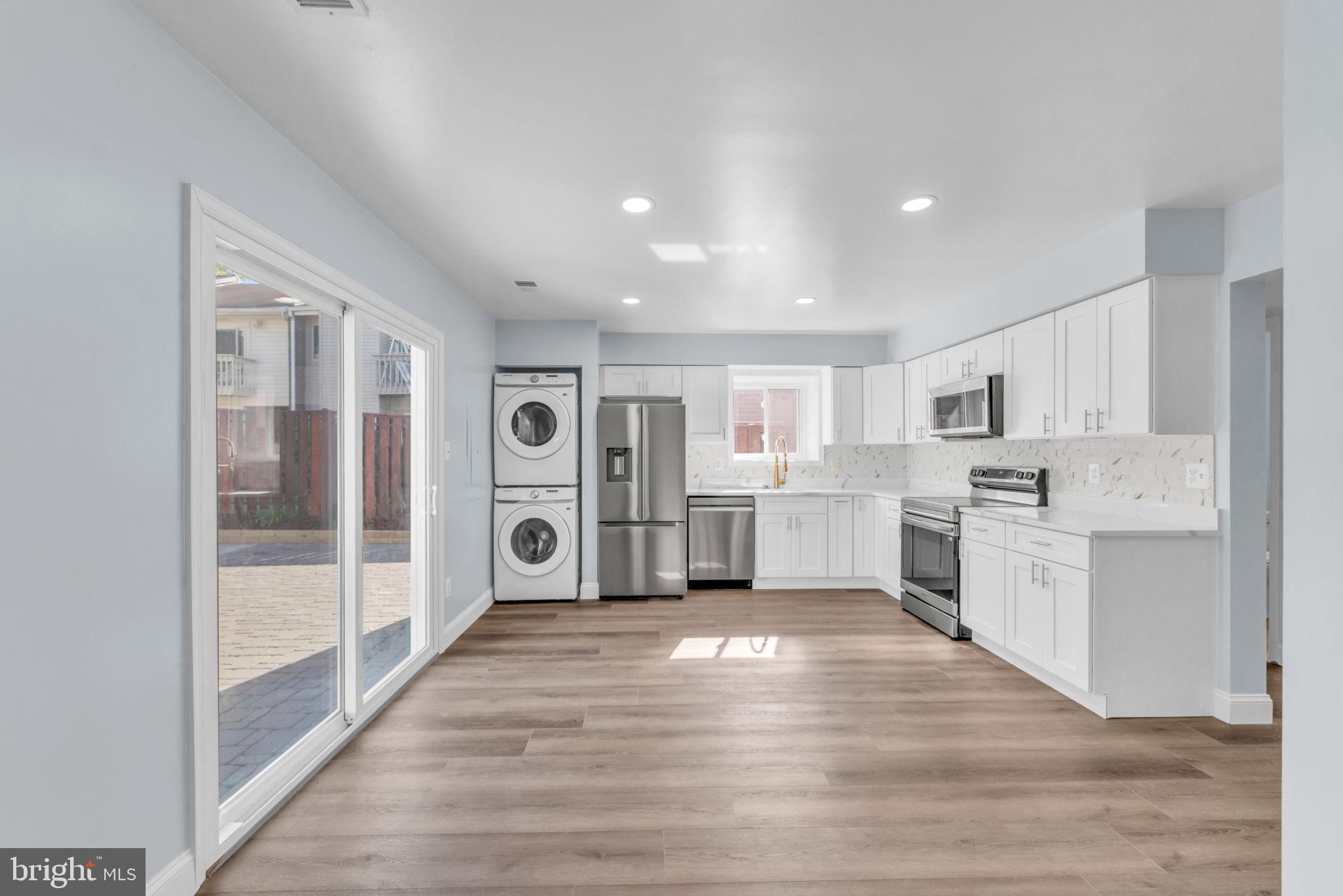 13314 Apgar Place Herndon, VA 20170 - Photo 12 of 39 a large white kitchen with cabinets a sink and a wooden floor