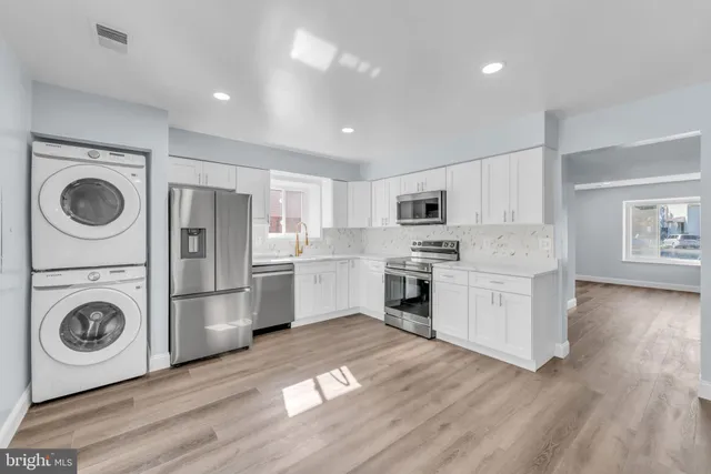 a kitchen with white cabinets and stainless steel appliances