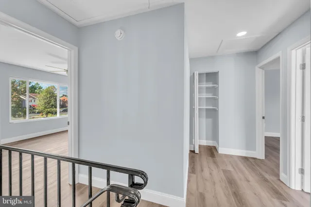 a view of a hallway with wooden floor and a window