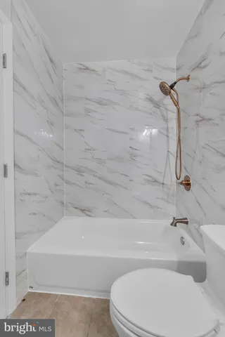 a bathroom with a toilet and a bath tub