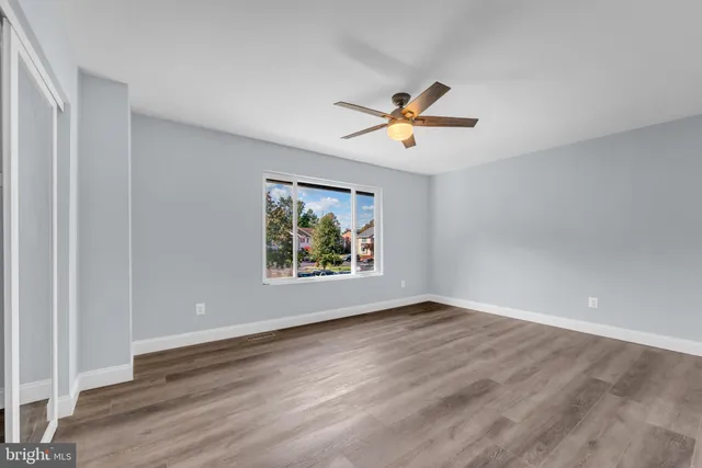 an empty room with wooden floor and window