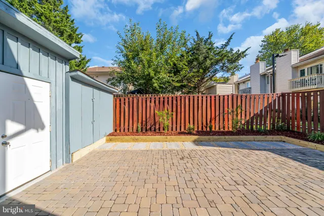 a view of backyard with wooden fence and trees