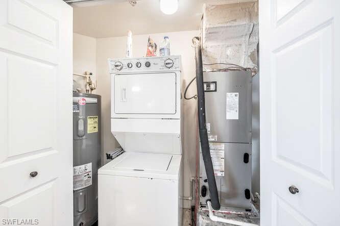 2745 First Street, Unit 104 Fort Myers, FL 33916 - Photo 21 of 39 Utility room with water heater and stacked washer / drying machine