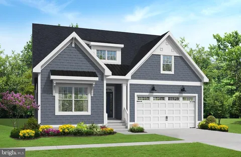 a front view of a house with a yard and potted plants