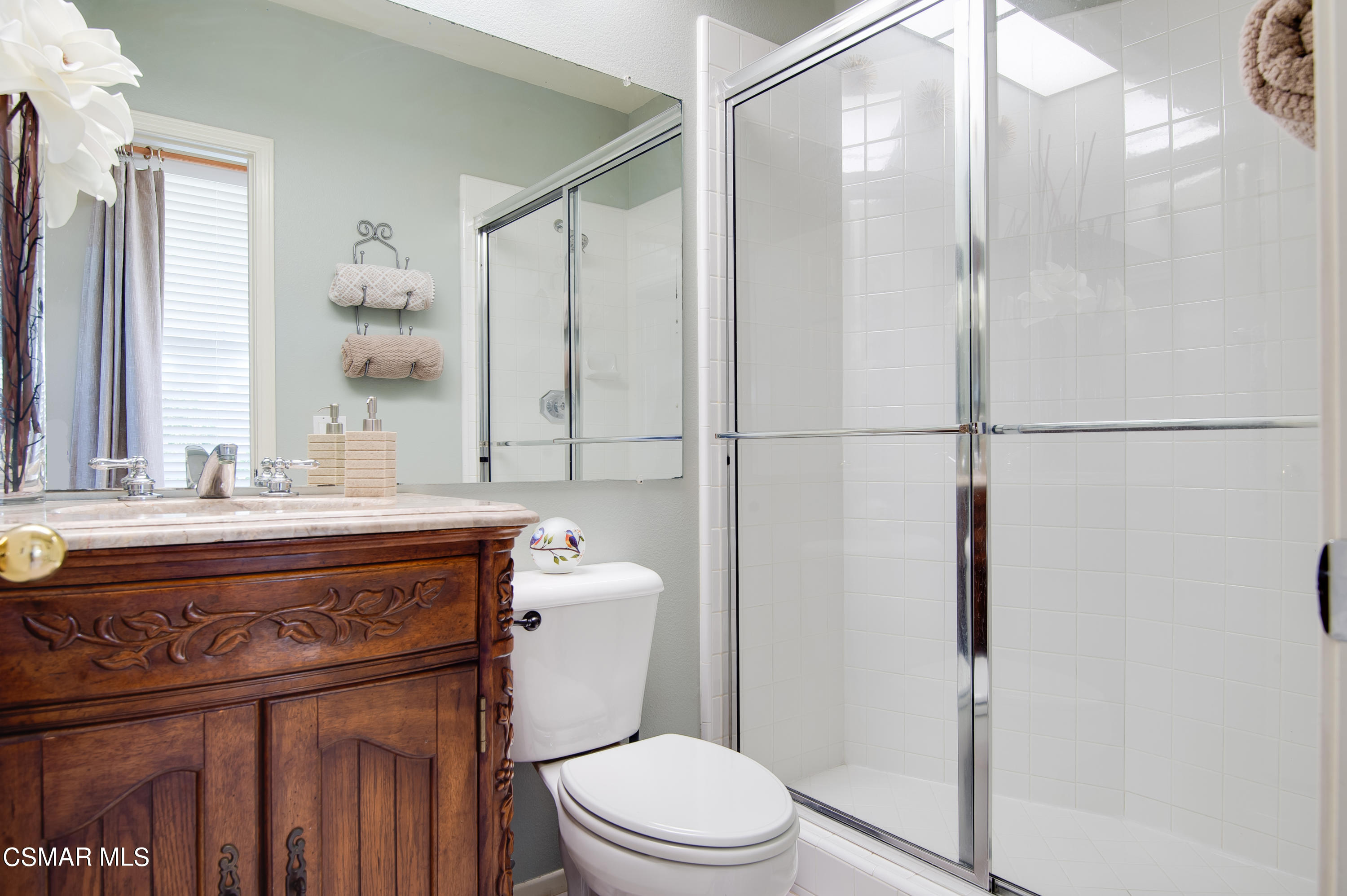 4348 Timberdale Road Moorpark, CA 93021 - Photo 17 of 35 a bathroom with a granite countertop sink toilet a mirror and shower