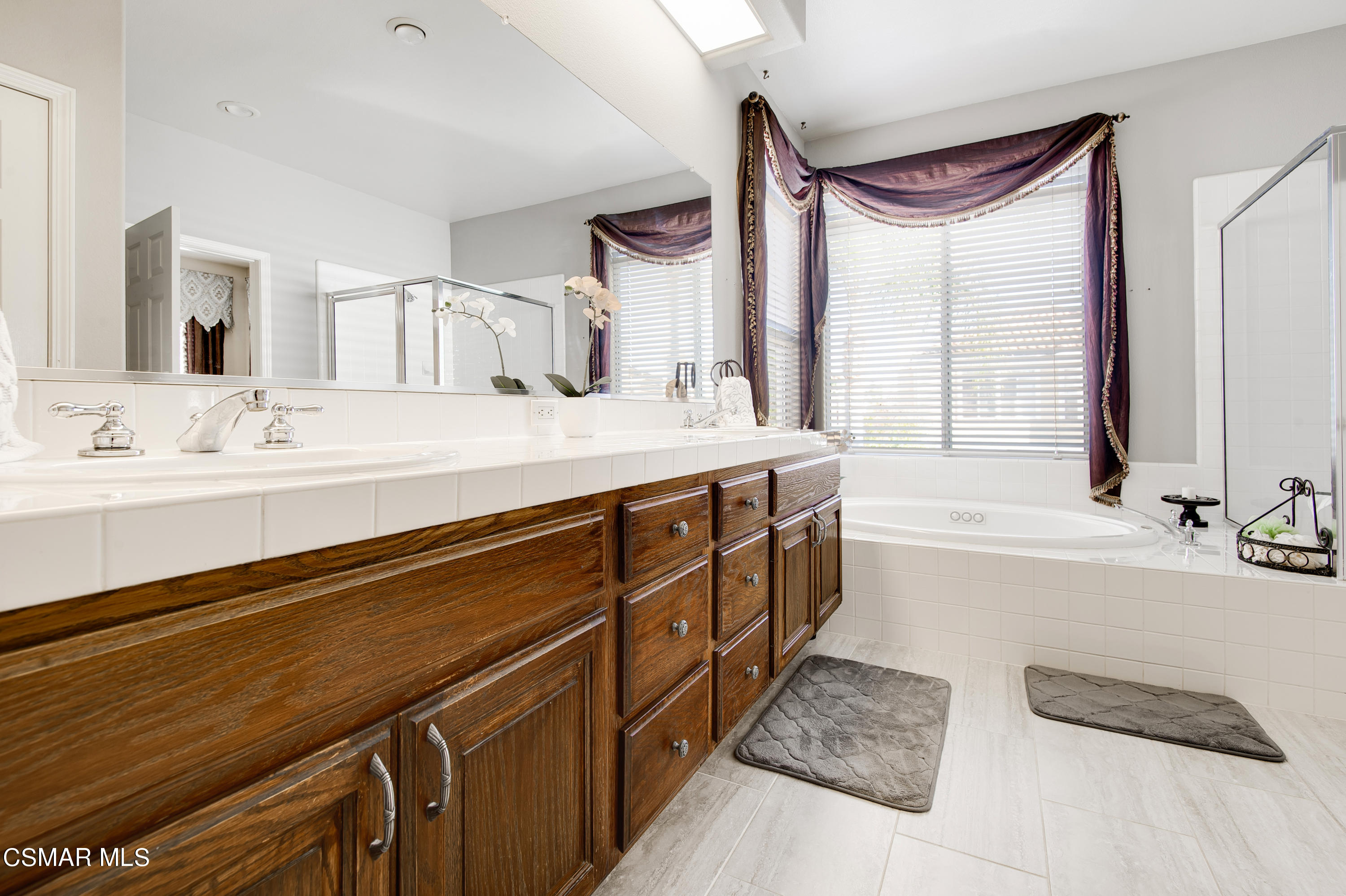 4348 Timberdale Road Moorpark, CA 93021 - Photo 22 of 35 a spacious bathroom with a double vanity sink a mirror and a bathtub