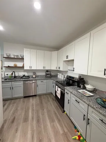 a large kitchen with granite countertop lots of counter top space and cabinets