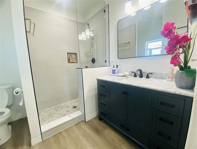 a bathroom with a double vanity sink mirror and toilet
