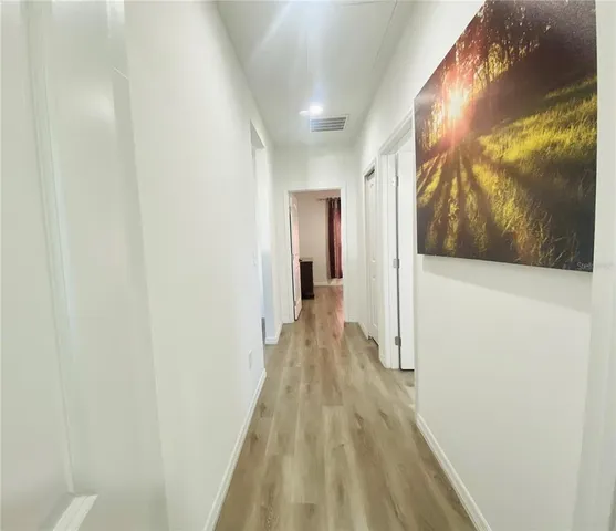 a view of a hallway with wooden floor