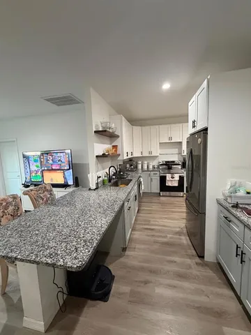 a kitchen with stainless steel appliances granite countertop a stove top oven a refrigerator a sink and dishwasher