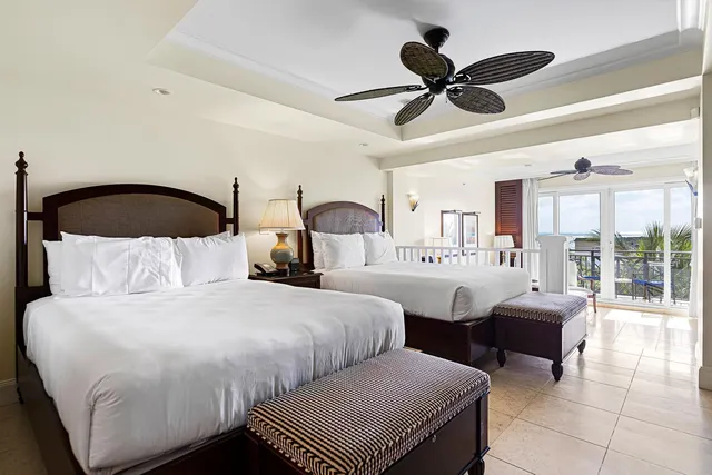 a bedroom with two beds and ceiling fan
