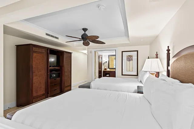 a bedroom with a large bed and a chandelier