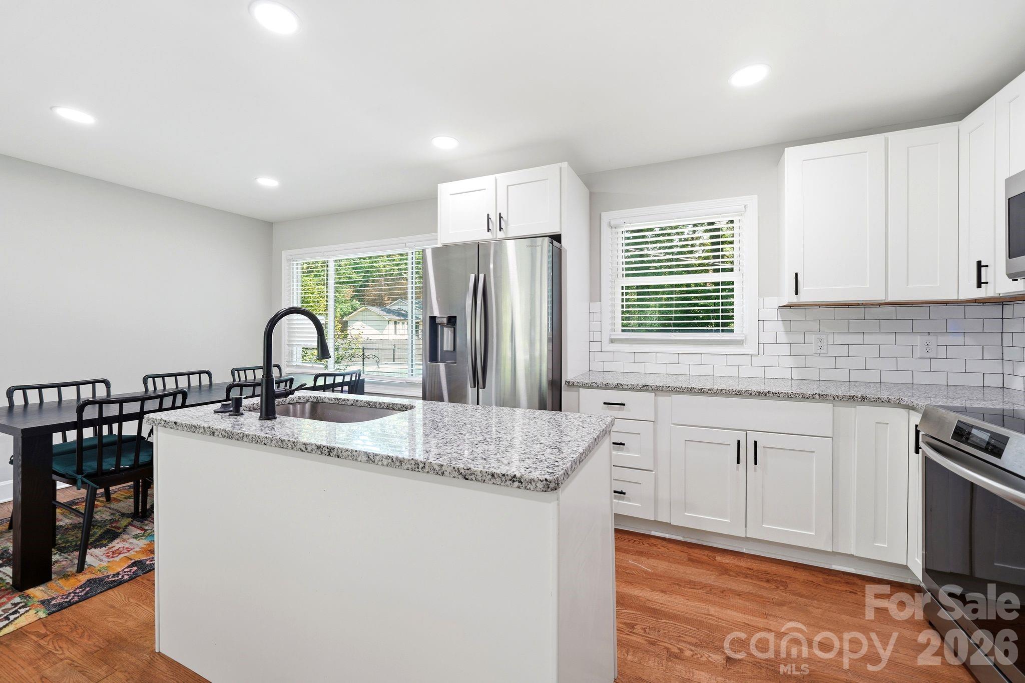 7552 Idlewild Road Charlotte, NC 28212 - Photo 4 of 40 a kitchen with stainless steel appliances granite countertop a sink stove and refrigerator