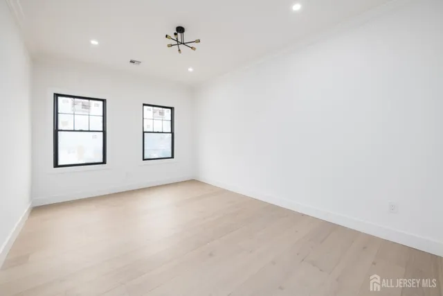 an empty room with windows and ceiling fan