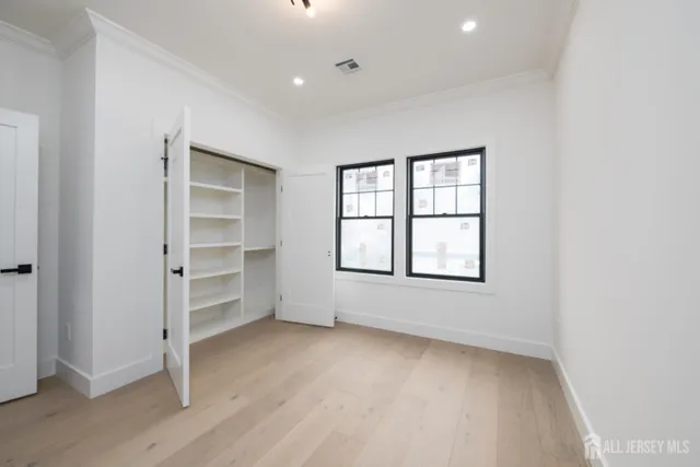an empty room with cabinet and windows