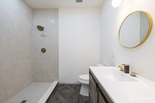 a bathroom with a sink a toilet and a mirror