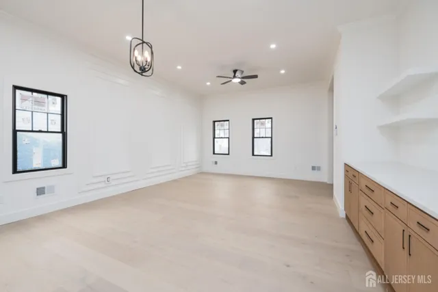 an empty room with windows and fan