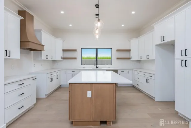 a large kitchen with stainless steel appliances granite countertop a sink a stove and a refrigerator