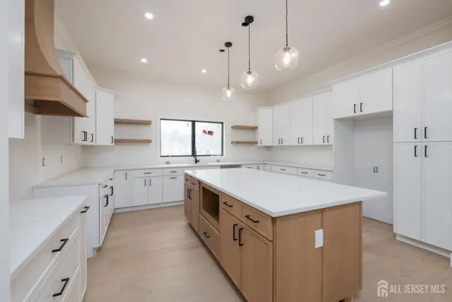 a kitchen with kitchen island a sink appliances and cabinets