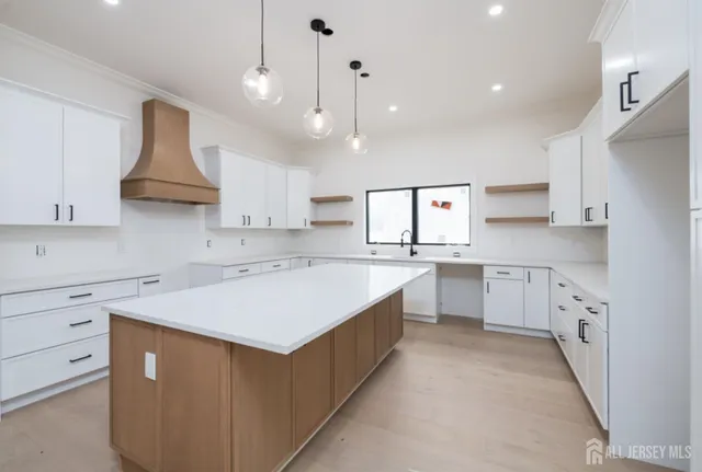 a kitchen that has a lot of cabinets in it and wooden floors