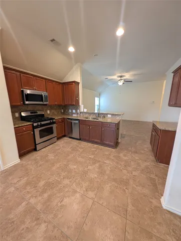 a kitchen with stainless steel appliances granite countertop a stove and a sink